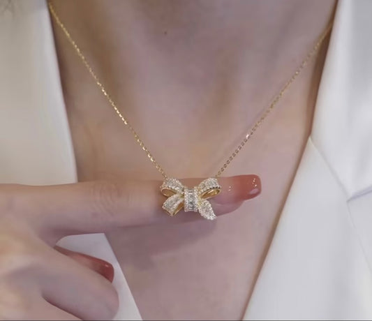 Golden elegant gold necklace with zironic sparkling bow pendant